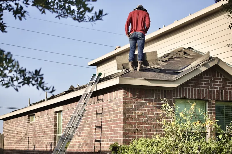 Professional roofer working on a residential roof in Henniker